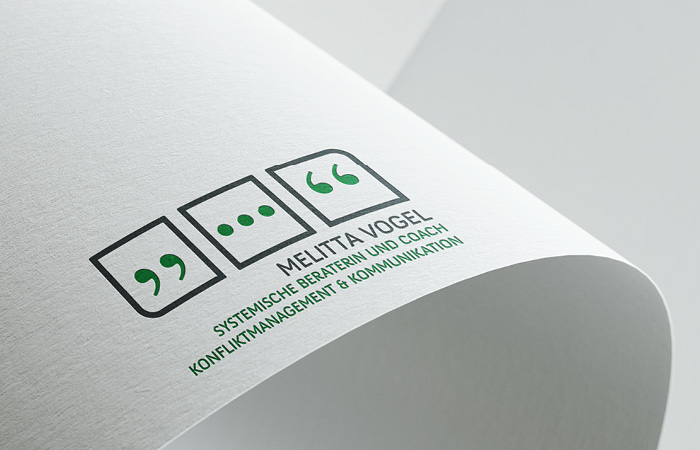 Logo Melitta Vogel, plastisch dargestellt auf einem gebogenen Blatt Papier